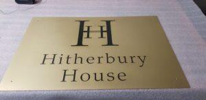 Satin brass plaque with engraved logo and black enamel lettering for Hitherbury House