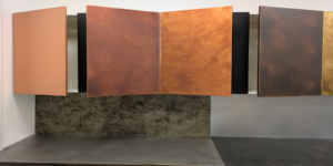 Copper kitchen cupboard doors in natural, light aged, dark aged, and antique patina finishes.