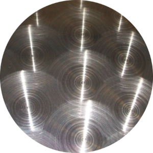Burnished circle stainless steel finish with circular brushed pattern creating reflective texture and industrial aesthetic