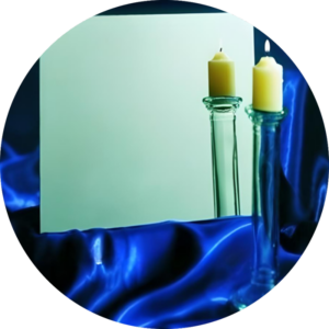 Super mirror stainless steel sheet with high reflective finish, showing candle reflection on blue satin fabric.