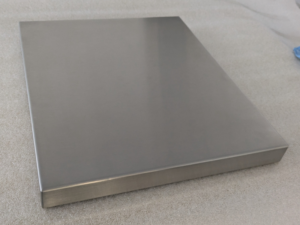 Brushed stainless steel table top with boxed-edge construction, TIG-welded corners, and smooth satin finish, fabricated by Metal Sheets Ltd in the UK.