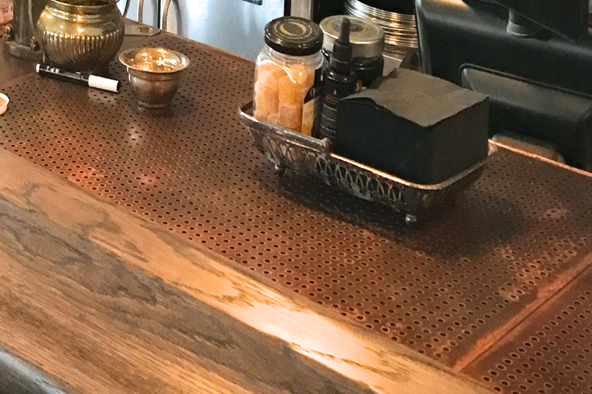 Copper bar counter panel with round perforations