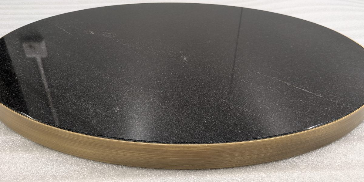 Round black table top with brass metal edge trim