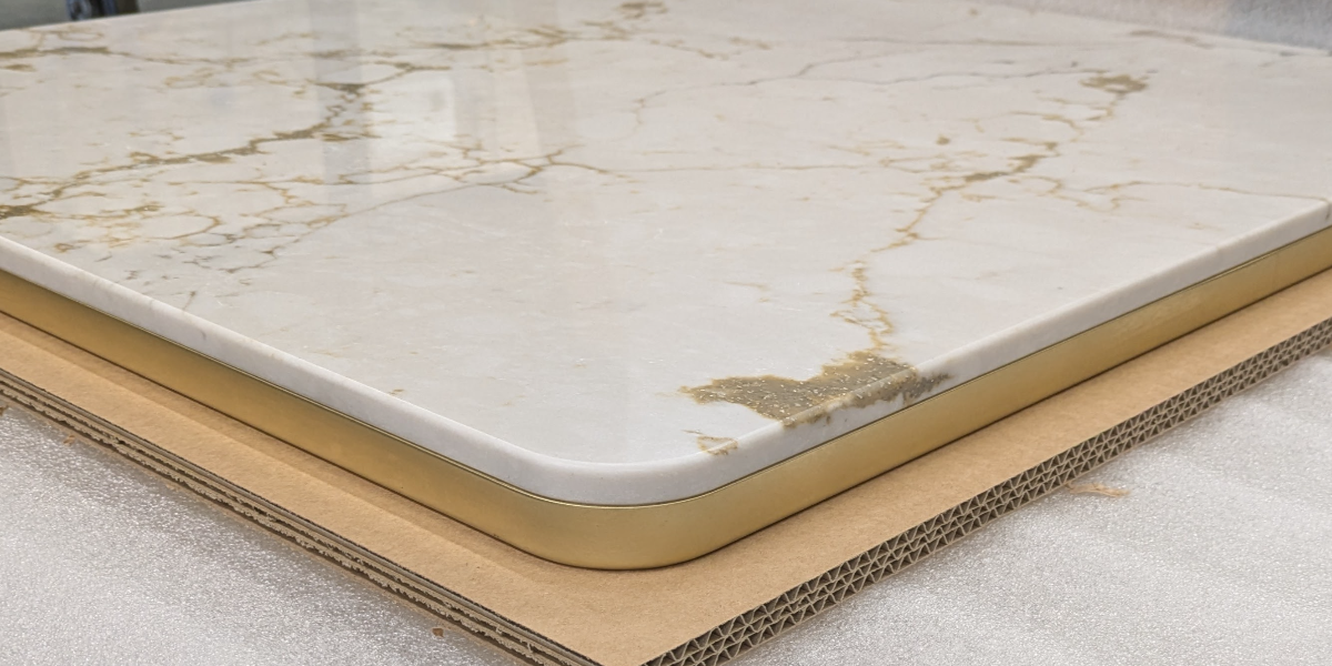 White marble table top with brass edge trim and rounded corner