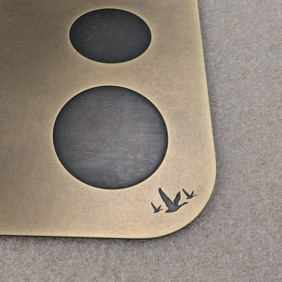 Close-up of engraved Grey Goose bird detail on an antique brass drinks cart component